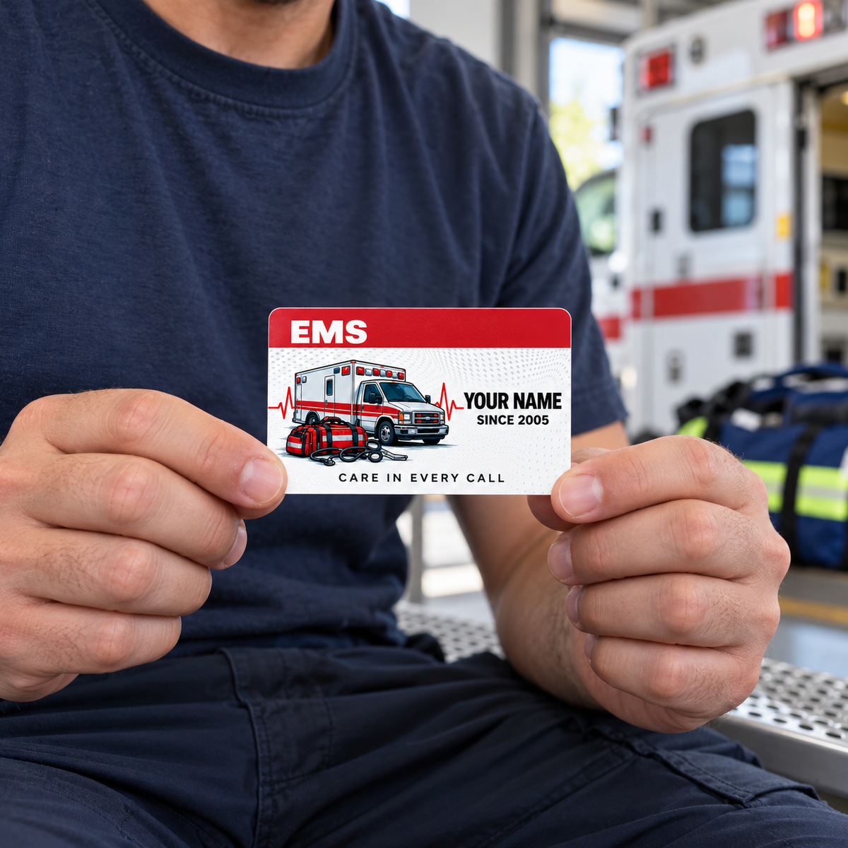 Adult male responder seated near an ambulance, holding the red-header EMS keepsake wallet card by its lower corners.