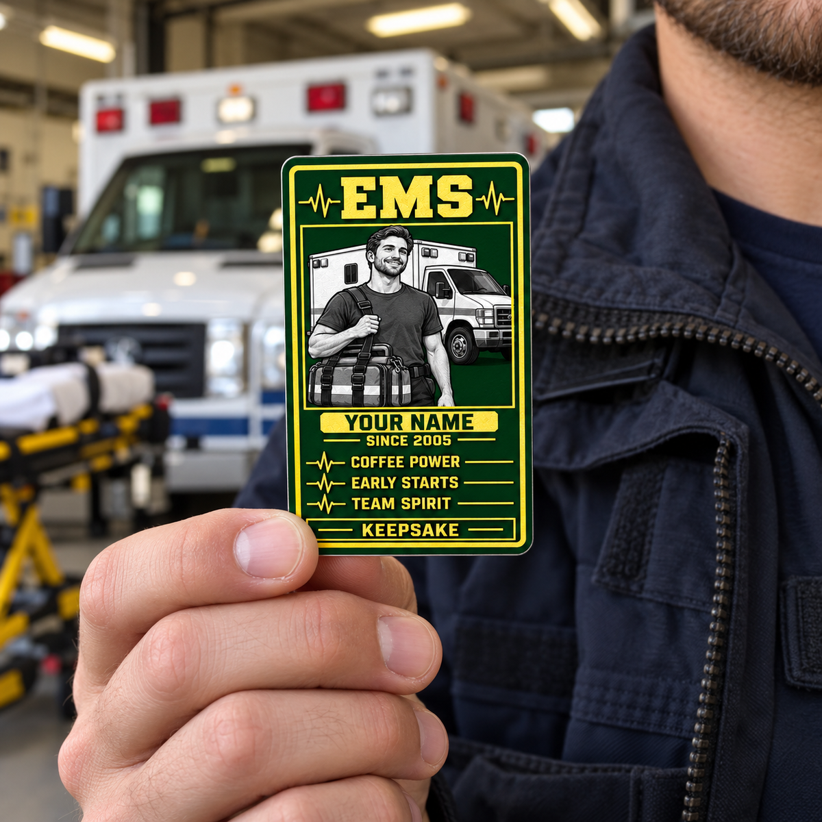 EMS Trade Legend portrait wallet card held by an adult worker near a parked ambulance.
