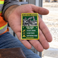 The printed front of the Excavator Operator Trade Legend Collectible aluminum wallet card shown in an occupational lifestyle setting with an adult worker.