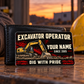 The printed front of the Excavator Operator Midnight Pride aluminum wallet card shown in an occupational lifestyle setting with an adult worker.
