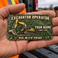 The printed front of the Excavator Operator Rugged Field aluminum wallet card shown in an occupational lifestyle setting with an adult worker.