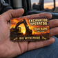 The printed front of the Excavator Operator Sunset Workday aluminum wallet card shown in an occupational lifestyle setting with an adult worker.
