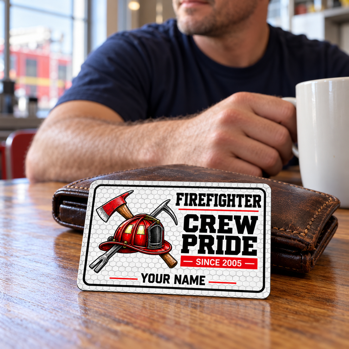 White honeycomb firefighter card beside a brown wallet as an adult man takes a coffee break at a station table.