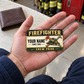 Firefighter heritage band wallet card resting on an adult man’s open palm at a fire station.