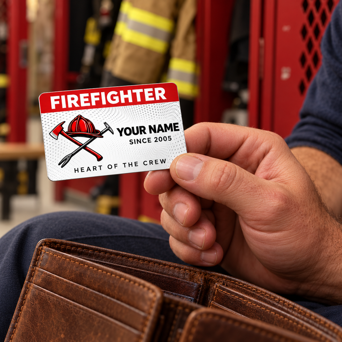 An adult man holds a red-header firefighter wallet card above his open wallet at a fire-station locker.