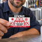 HVAC Red Monochrome aluminum wallet card held at its lower-left corner by an adult technician taking a workshop coffee break.