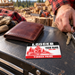 Logger wallet card in a forest logging rest area with an adult man and leather wallet.
