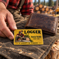 Logger wallet card in a forest logging rest area with an adult man and leather wallet.
