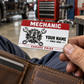 Mechanic Red Header aluminum wallet card held above an open leather wallet in an automotive garage.
