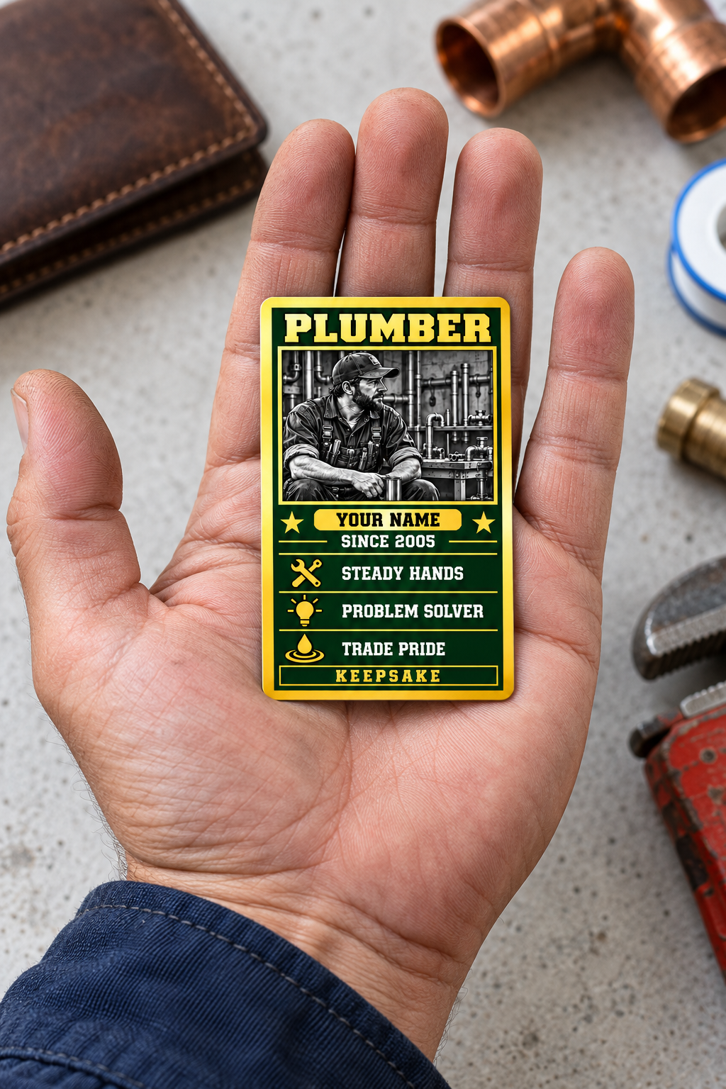 The printed front of the Plumber Trade Legend Collectible aluminum wallet card shown in an occupational lifestyle setting with an adult worker.