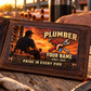 The printed front of the Plumber Sunset Workday aluminum wallet card shown in an occupational lifestyle setting with an adult worker.
