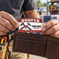The printed front of the Roofer Red Header Trade Pride aluminum wallet card shown in an occupational lifestyle setting with an adult worker.