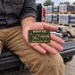The printed front of the Roofer Rugged Field Pride aluminum wallet card shown in an occupational lifestyle setting with an adult worker.