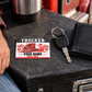 Trucker Red Monochrome card on a charcoal toolbox beside a truck key and closed wallet