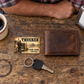 Trucker Sepia Legacy wallet card on a worn wooden break table beside a closed wallet and truck key