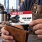 Adult welder holds the Red Header wallet card above a brown wallet during a workshop break