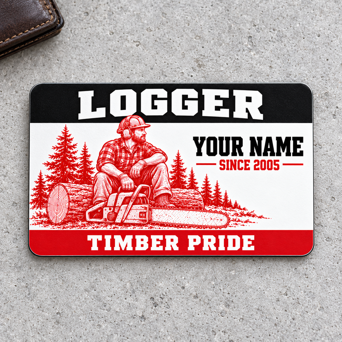 Logger Red Monochrome aluminum wallet card front on gray concrete with a leather wallet edge.