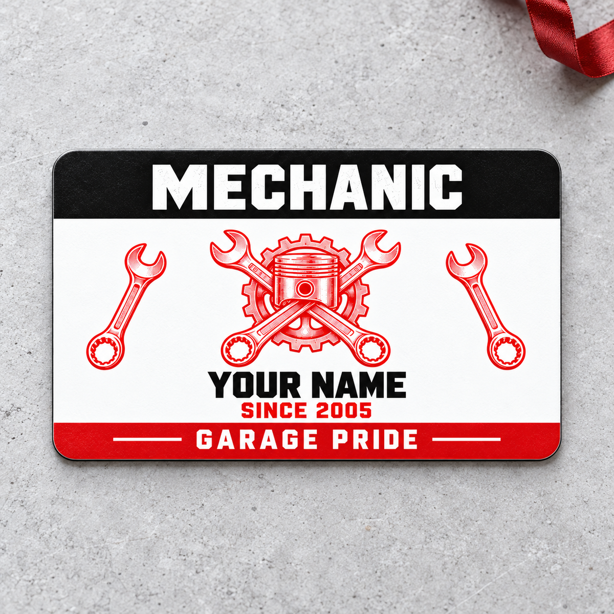 Front of Mechanic Red Monochrome aluminum wallet card on pale concrete with red ribbon.