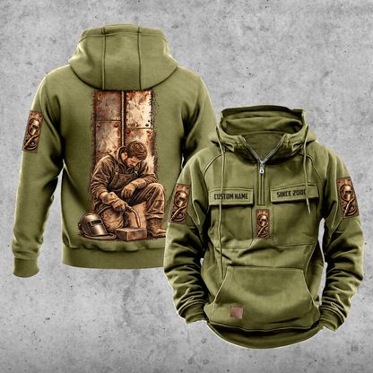 Welder Daily Commitment Portrait Vintage Hoodie in Military Green, front and back views with sample text CUSTOM NAME and SINCE 2000, tall steel-panel kneeling welder artwork, small sleeve motifs and plain lower pouch.